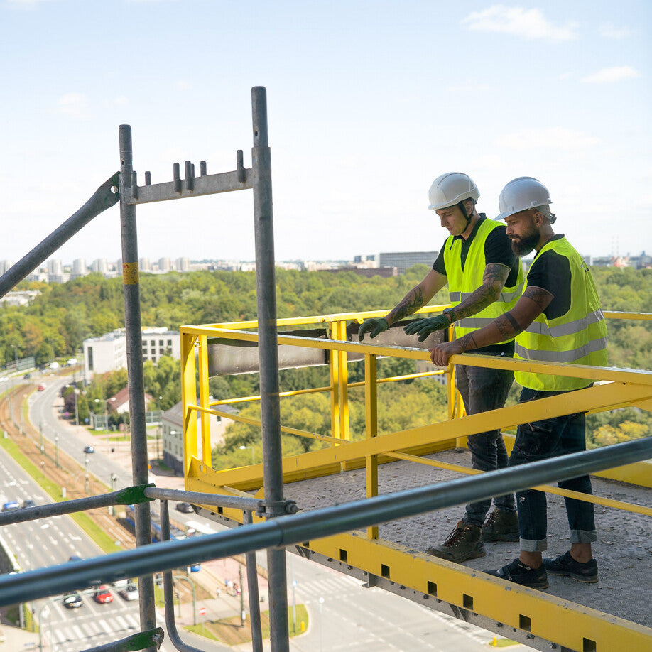 Radnici na istovarnoj platformi za kran s otvorenom ogradom